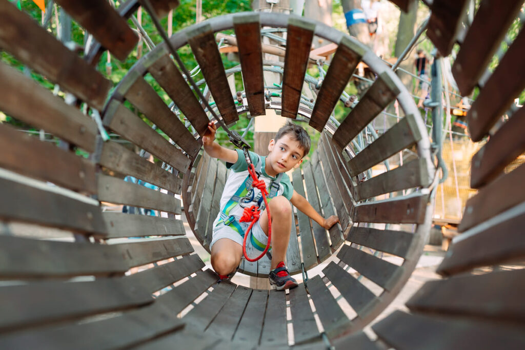 Niño jugando dentro de un tubo de madera en el parque